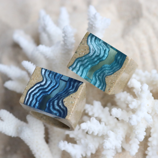Two rift blue resin statement rings on white coral